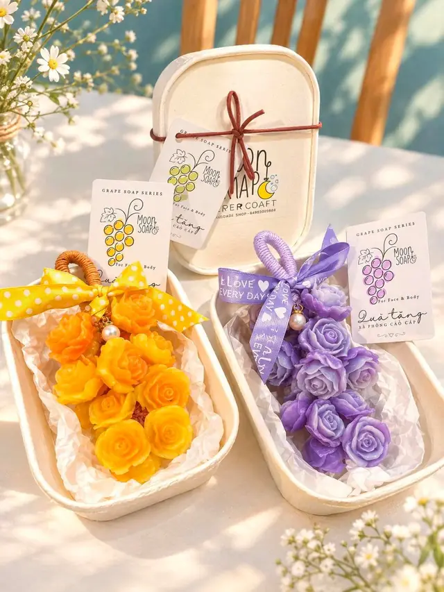 Hai chùm xà phòng hoa hồng vàng và tím trong hộp quà Moon Soap, kèm thẻ quà tặng xà phòng Chùm Nho